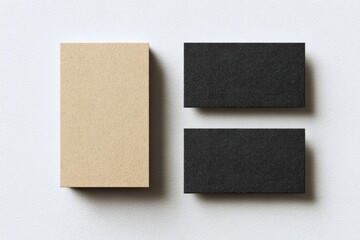 Fototapeta premium Two blank business cards, one beige, one black, on a white surface