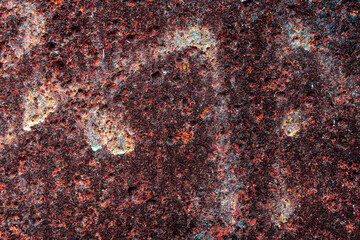 close-up of a red metal panel with traces of white paint on the surface of an old textured structure to be used as a background