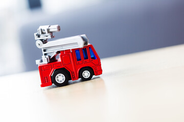 A delightful Miniature Red Fire Truck Toy is placed on a wooden table