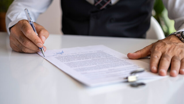 Close up business man signing contract