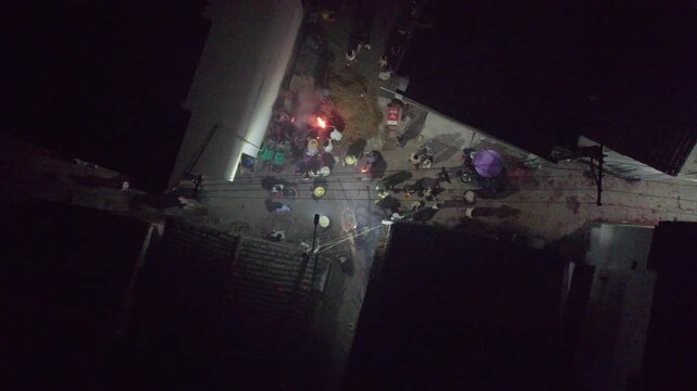 Drone view of crowded people burning incense during New Year celebrations in Wuyuan, Jiangxi, China. Top view of villager prepare grass dragon dance in spring festival at night, 4k real time footage.