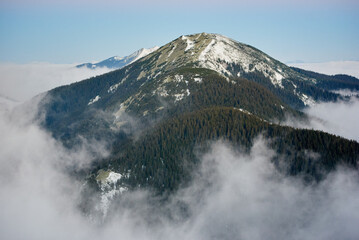 Breathtaking photograph showcases majestic mountain peak, partially covered with snow and...