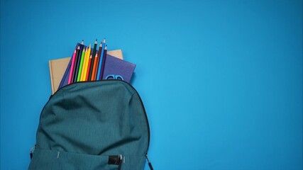 Colorful school supplies moving from school bag on blue background. Back to school concept. Stop motion animation - Powered by Adobe