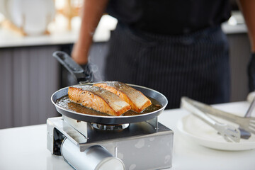 chef cooking salmon steaks in the kitchen