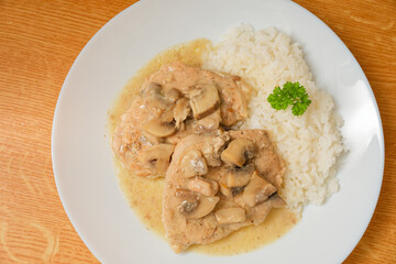 Pork meat gravy with mushrooms and rice on plate