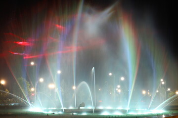Abstract background. Motion blurred colorful fountain at night
