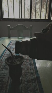 Manos cebando mate al amanecer sobre la mesa