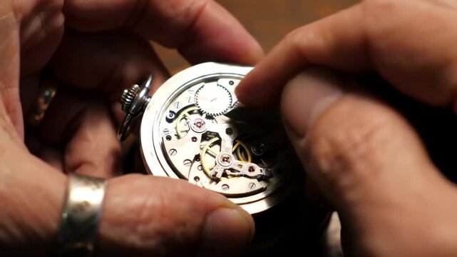 Skilled artisan’s hands meticulously performing intricate repairs on the delicate internal mechanisms of a classic mechanical timepiece, revealing complex gears and spring components