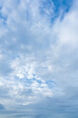 High resolution image of a partly cloudy blue sky White and grey cumulus clouds are scattered across the sky