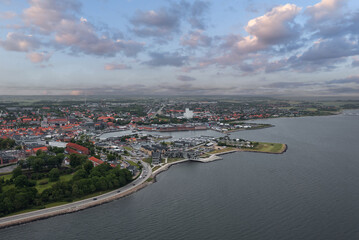 Cityscape of Thisted, Denmark — Skyline view of historic houses, white church, marina, and dramatic sky over the Limfjord waterfront in North Jutland