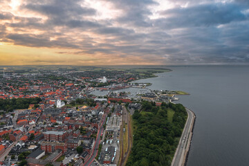 Daytime aerial panorama of Thisted, Denmark — Skyline view of historic houses, white church, marina, and dramatic sky over the Limfjord waterfront in North Jutland