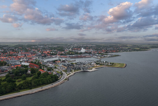 Cityscape of Thisted, Denmark &mdash; Skyline view of historic houses, white church, marina, and dramatic sky over the Limfjord waterfront in North Jutland