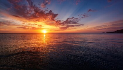 Obraz premium beautiful orange and red hues paint the sky as the sun dips below the horizon casting a golden reflection on the calm ocean water