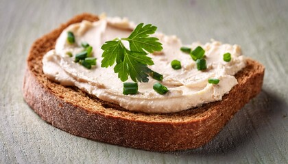 close up of rustic bread slice with savory spread and herbs