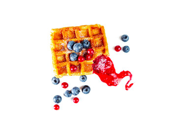 Belgian waffles with fresh berries and jam isolated on white background.