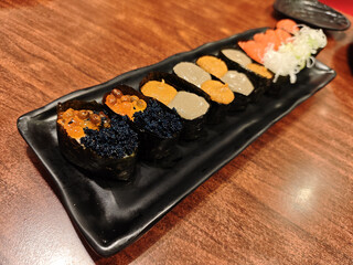 Delicious japanese food long plate of gunkan sushi with savory tobio and ikura topping makes for an...