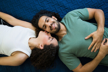 Top viewo of a happy couple relaxing and kissing on bed