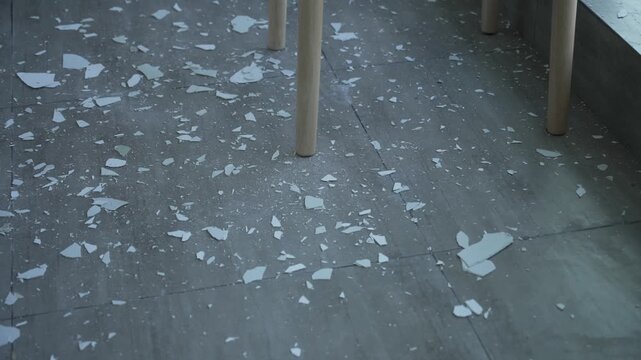 Concrete floor with scattered white debris and partial table legs in indoor setting
