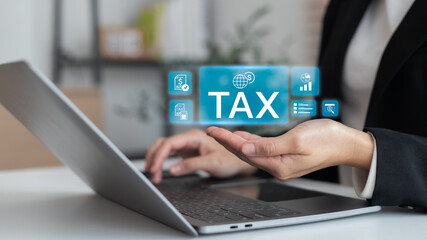 Businesswoman using laptop with digital tax and accounting icons, concept of online tax filing, financial report, business finance, and modern technology.