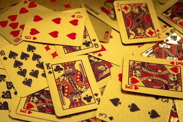 A scattered collection of playing cards covers a surface, displaying various suits and numbers in a casual arrangement.