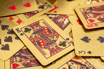 A scattered collection of playing cards covers a surface, displaying various suits and numbers in a casual arrangement.