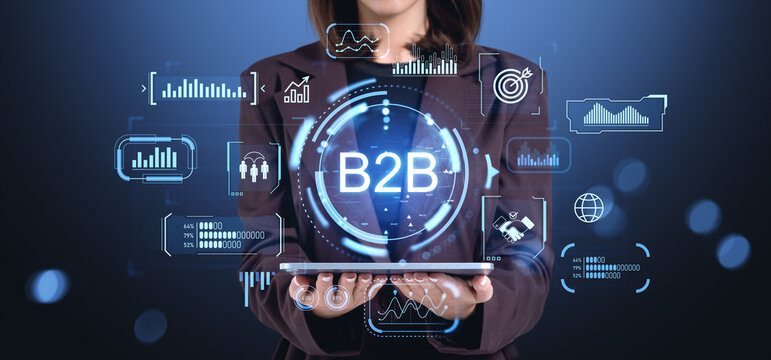 Businesswoman holding tablet with B2B icons and analytics interf