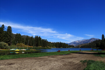A tourist recreation center in the mountains. In the middle of the photo there is a small lake with yachts and sun loungers