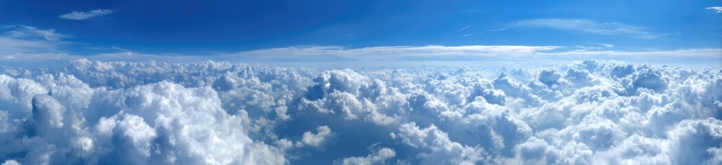 Vast expanse of fluffy white clouds against a vibrant blue sky