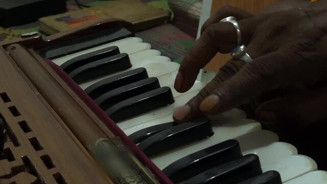 Indian man hands playing ethnic Indian classical harmonium keyboard on stage, close up view. Entertainment, music, culture, leisure time and art concept