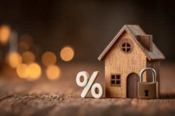 Home loan interest rates affect affordability, symbolized by a wood house, percentage and padlock.