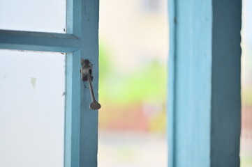 Close-up of a traditional Taiwanese wooden window latch, used to secure early wooden windows in old houses. The latch reflects historical craftsmanship and aged textures.