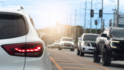 Heavy traffic on a city road during rush hour. The sun creates a warm lens flare highlighting the...