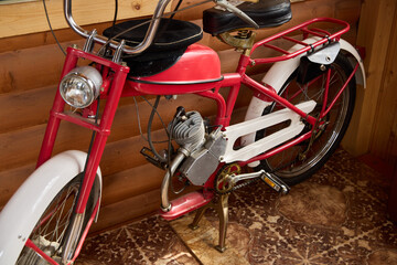 A vintage red motorized bicycle with striking white accents, ideal for enthusiasts