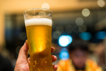 Hand holding pint of cold beer