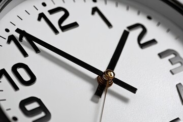 Close-up of a white wall clock with black hands