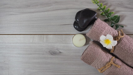 Spa-like setting with candles, flowers, and towel  Relaxing spa setup with towels and candle on...