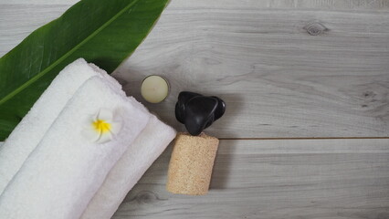 Spa-like setting with candles, flowers, and towel  Relaxing spa setup with towels and candle on...