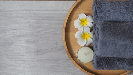 Spa-like setting with candles, flowers, and towel  Relaxing spa setup with towels and candle on...
