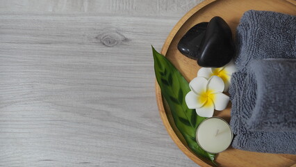 Spa-like setting with candles, flowers, and towel  Relaxing spa setup with towels and candle on...