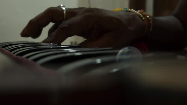 Indian man hands playing ethnic Indian classical harmonium keyboard on stage, close up view. Entertainment, music, culture, leisure time and art concept