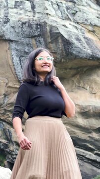 4K Vertical shot of Indian woman walk in front of mountain in Sural bhatori, Pangi Valley, India. Female tourist exploring hidden gems of Himalayas. Travel, adventure and hiking concept.