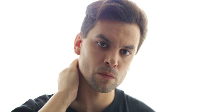 A man looks with a predatory gaze dominant, throwing his arm behind his head