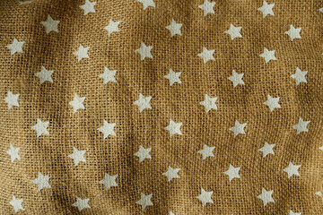 Burlap fabric with painted stars arranged to form a charming decorative background.