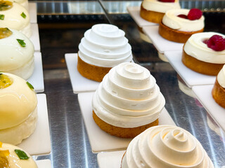 Elegant mousse cakes with white cream swirl topping. Culinary creativity, delicate flavors, and modern pastry design.