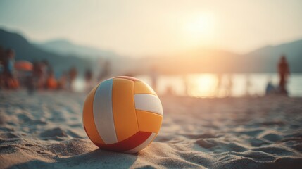 A volleyball rests on sandy beach at sunset, with blurred people and mountains in the background, creating a relaxed summer atmosphere