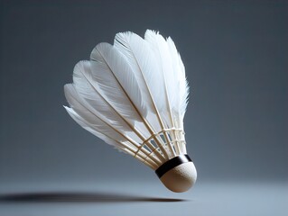 Dynamic White Badminton Shuttlecock Suspended in Mid-air, Showcasing Delicate Feathers and Textured Cork Base on a Minimalist Background