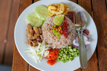 Tradition thai food : Nam prig Kapi is shrimp paste mix chili sauce served with boiled and fresh vegetables the table. Steamed rice and boiled egg served with fried fish and shrimp paste. Popular food