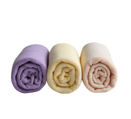 Three rolled towels in pastel colors