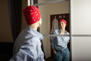 Woman in casual outfit with red bandana looking at reflection, concept of resilience, empowerment...
