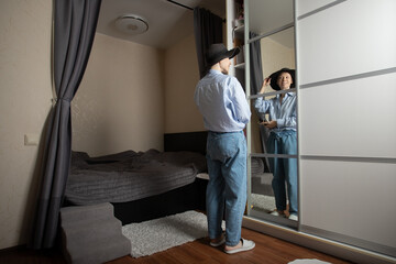 Confident woman checking appearance in mirror, concept of personal style, self-care and...